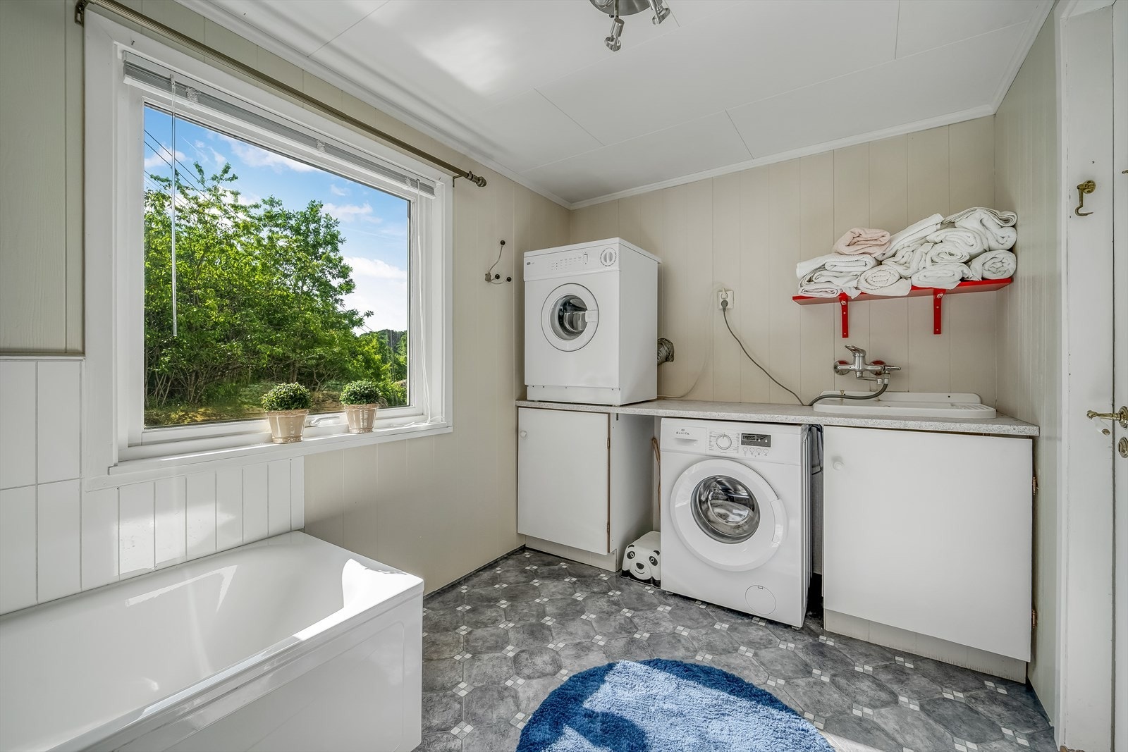 Badet er innredet med baderomsinnredning, toalett, badekar og opplegg for vaskemaskin. Galleribilde