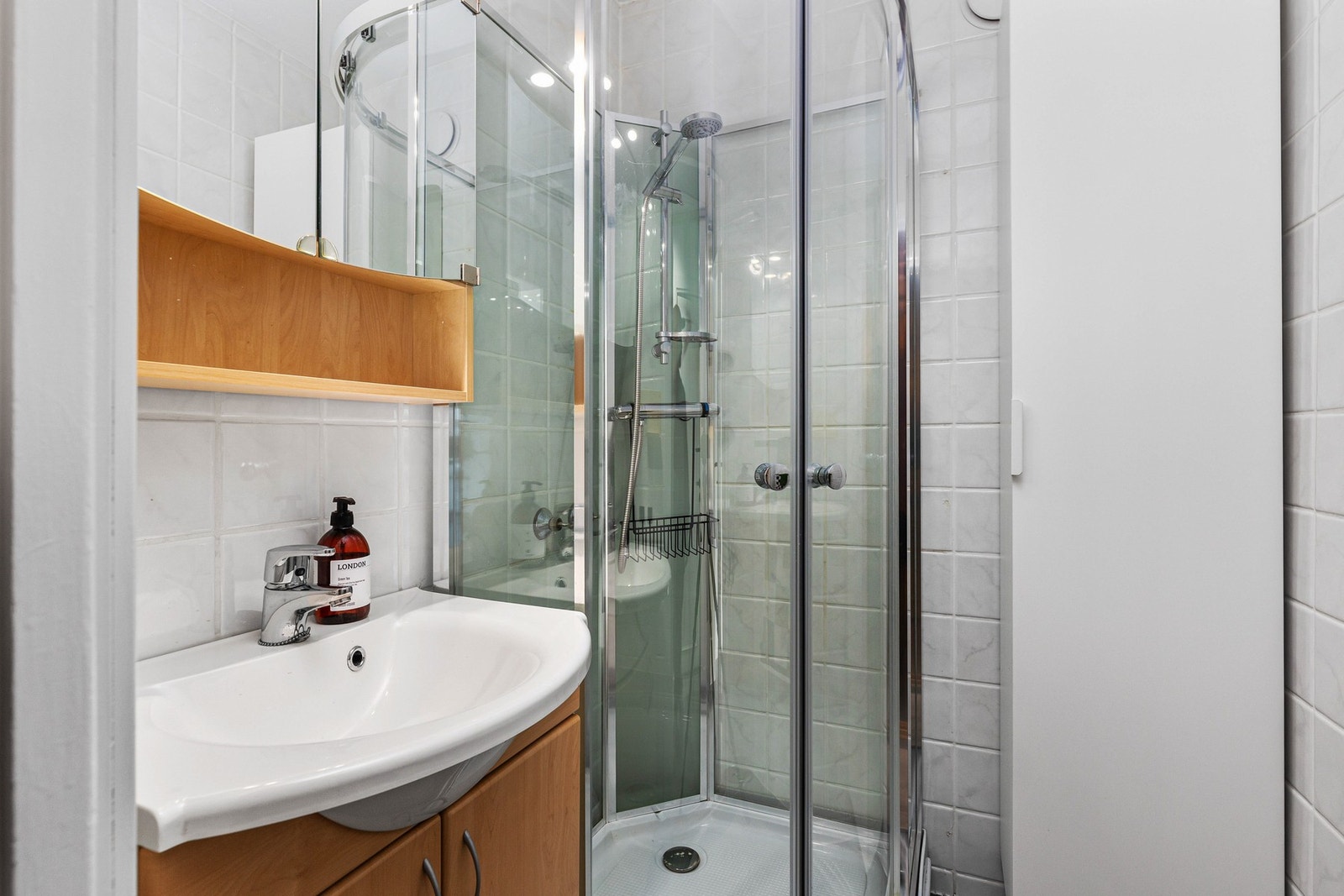 Flislagt bad med gulvvarme. Innredningen består av dusjkabinett og servant, og toalett er i separat rom. Galleribilde