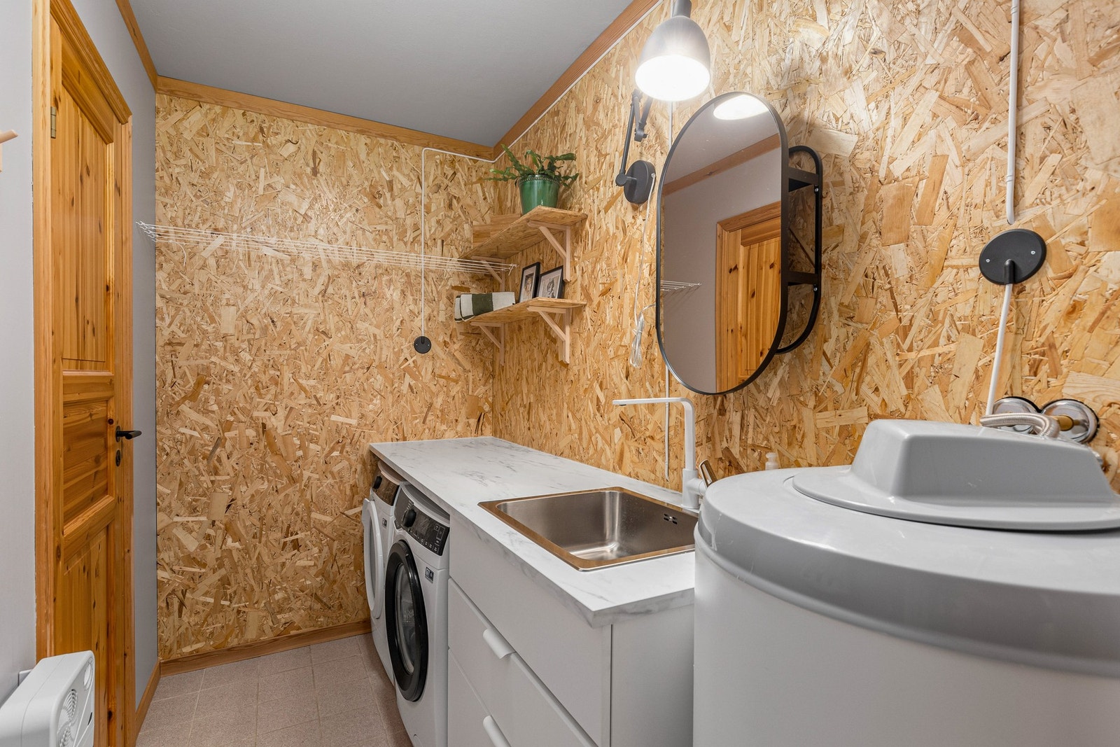 Leiligheten har også et svært praktisk vaskerom med fin innredning og opplegg for vaskemaskin og tørketrommel. Galleribilde