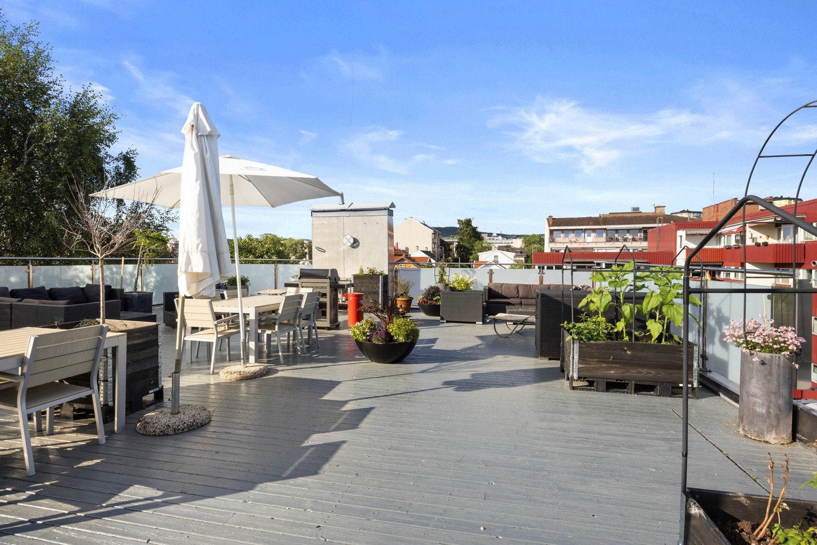 Takterrasse med panoramautsikt utover byen og Rodeløkkaflere med sittegrupper, grill og et lite drivhus. Galleribilde