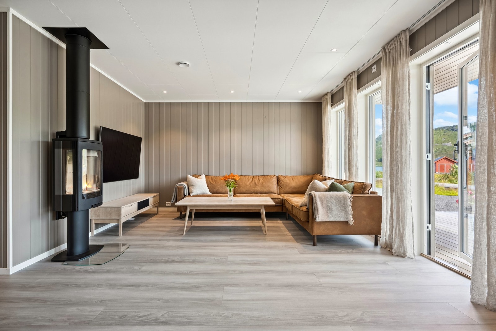 Romslig stue med lyse overflater og downlights i tak. Galleribilde