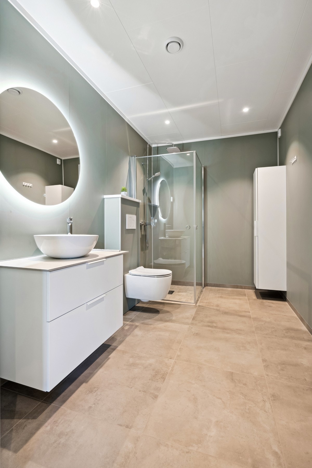 Moderne bad som er godt belyst med lys bak speil og spotter i taket. Galleribilde