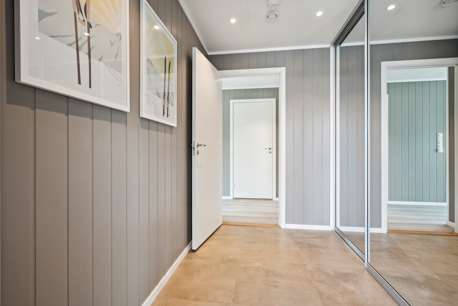 Velkommen inn i entréen med fliser på gulv, spotter i tak og skyvedørsgarderobe. Galleribilde