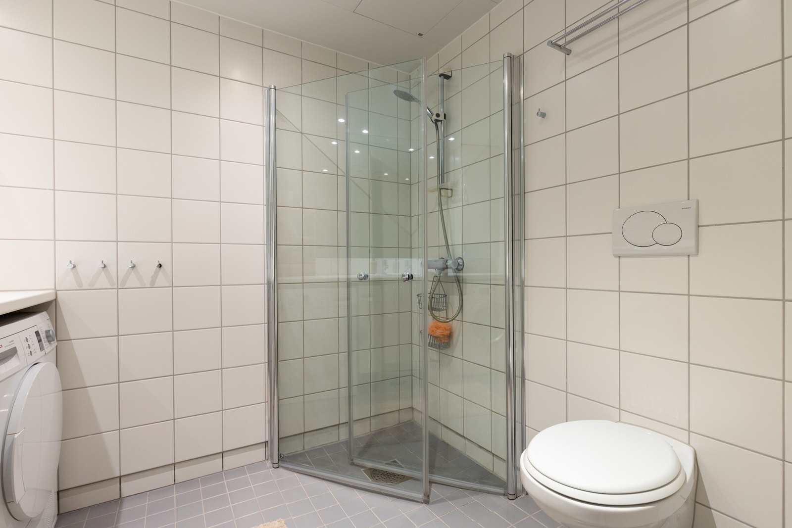 Videre er det vegghengt toalett og dusjhjørne med svingbare glassdører som frigjør plass på gulvet. Galleribilde