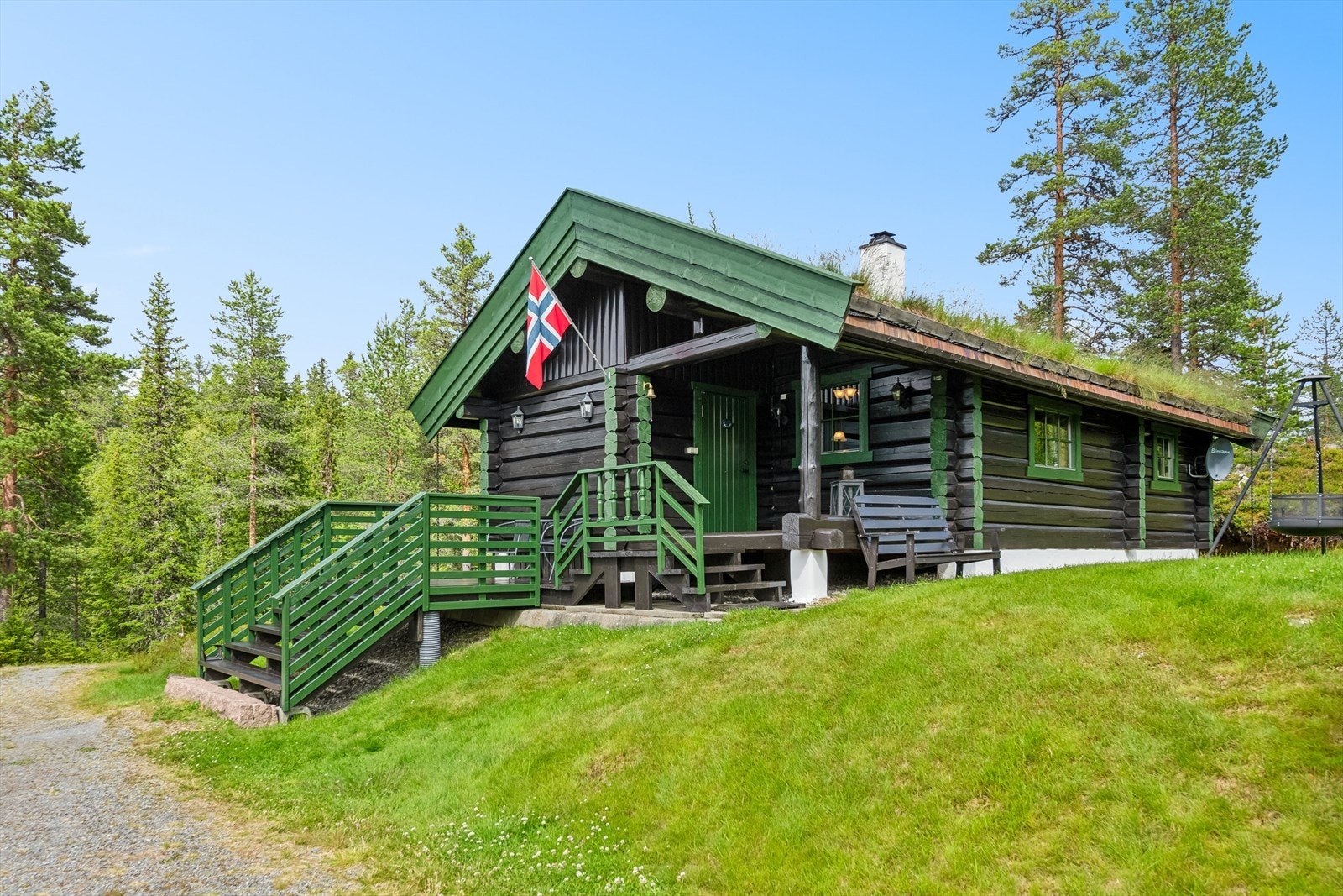 Overbygget terrasse ved inngang til boligen og terrasse i tilknytning til trapper ned til terreng. Galleribilde