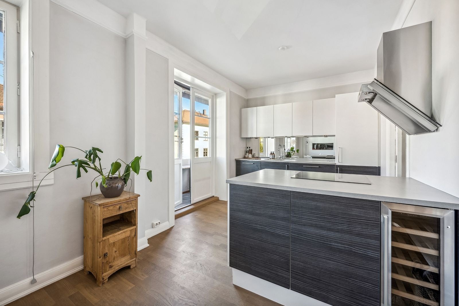 Lekkert kjøkken med integrerte hvitevarer og vinskap. Galleribilde