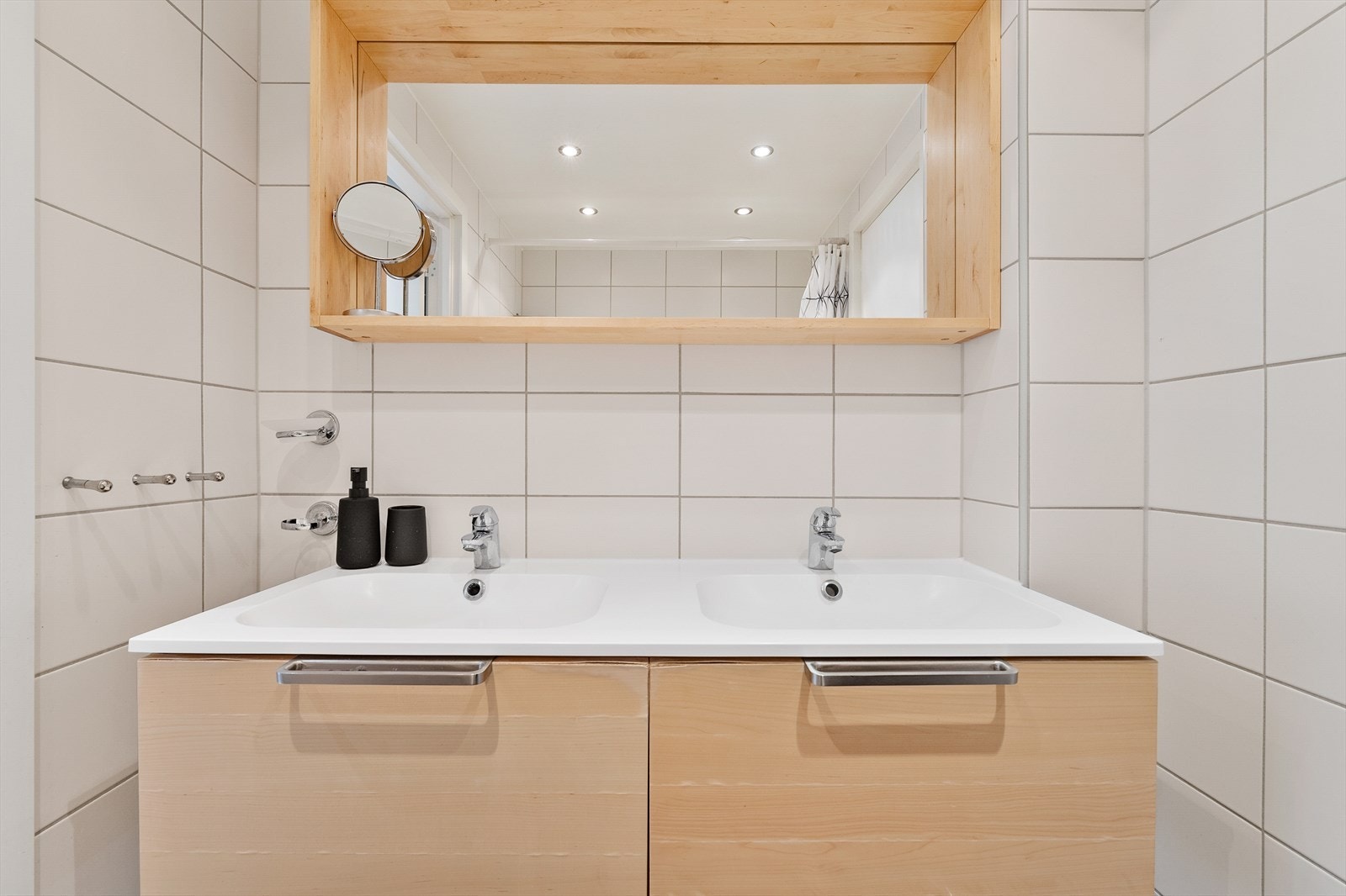 Badet utstyrt med badekar, servantinnredning med 2 formstøpte servanter med skuffer og speil, samt kran for vaskemaskin. Galleribilde