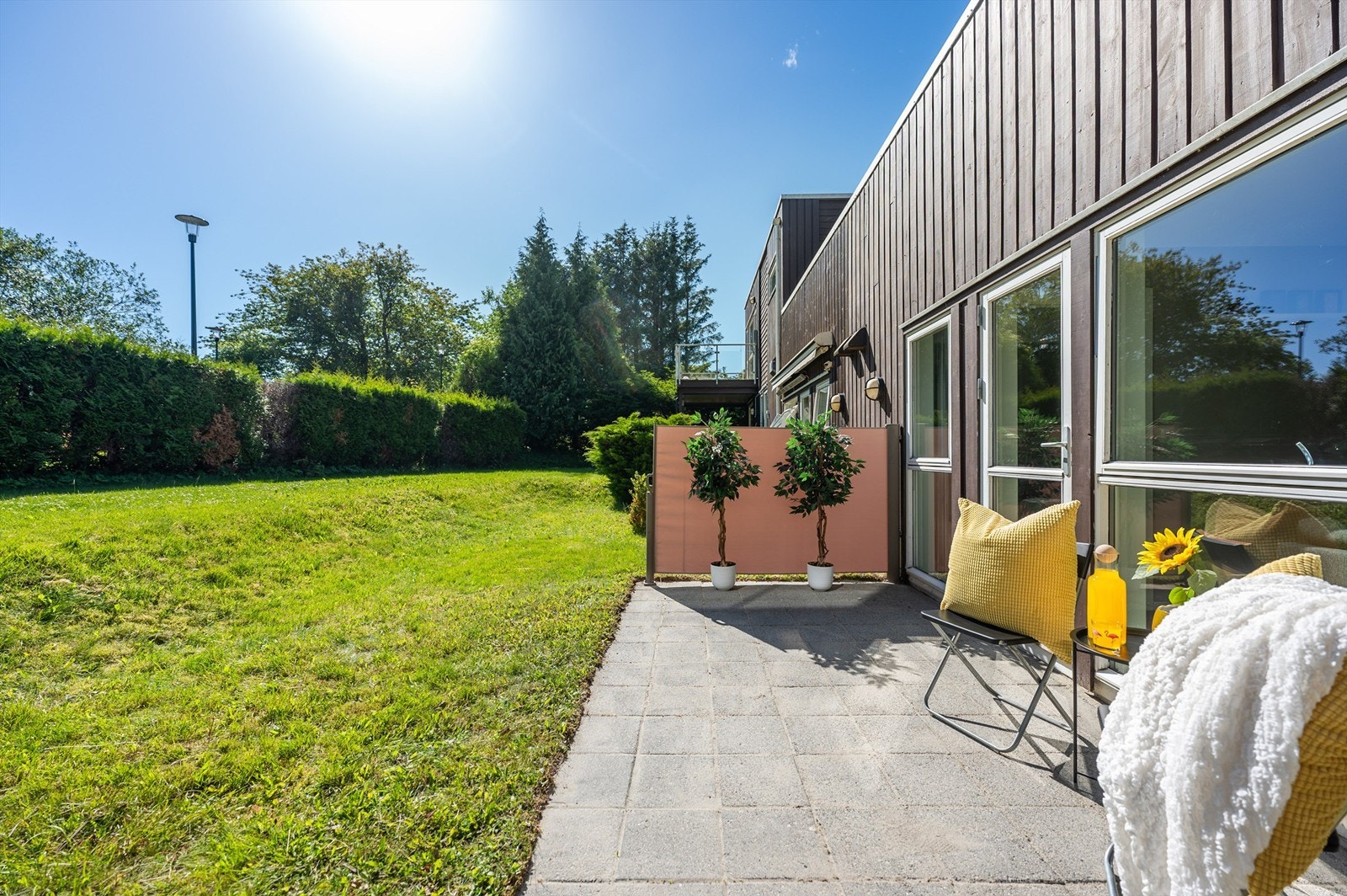 Foran leiligetens terrasse er det skjermet og lun plen. Bak hekken er det en koselig lekeplass. Galleribilde
