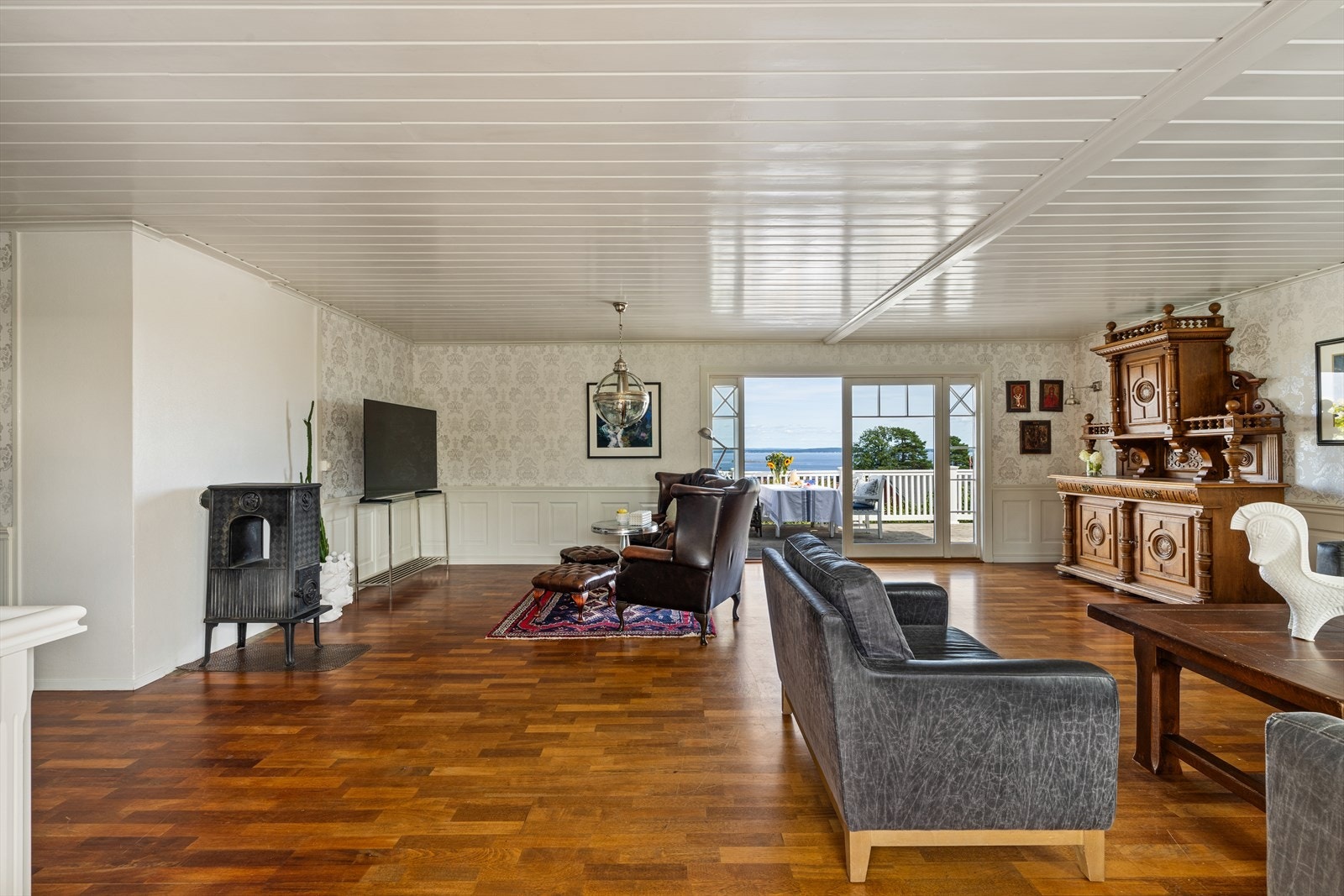 Det er en lys og hyggelig stue med utgang til terrassen og til hagen på motsatt side. Galleribilde