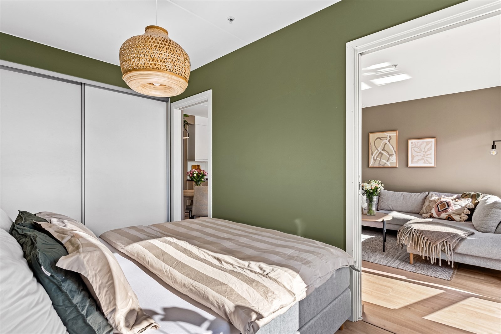 Stor skyvedørsgarderobe med glatte fronter er montert langs veggen, som sørger for gode oppbevaringmuligheter. Galleribilde
