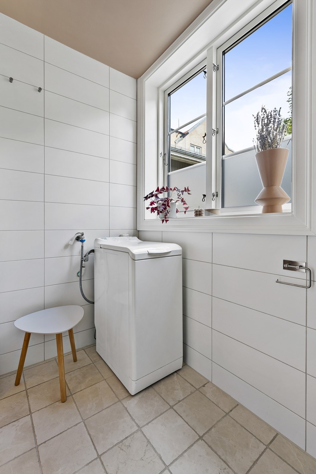 Til venstre i gangen kommer man inn på badet. Det er flislagt og tidløst med plass til vaskemaskin. Denne følger med salget. Galleribilde