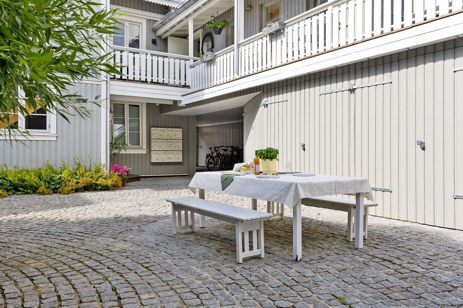 Koselig bakgård/gårdsrom med belegningsstein og utemøbler til felles bruk. Galleribilde