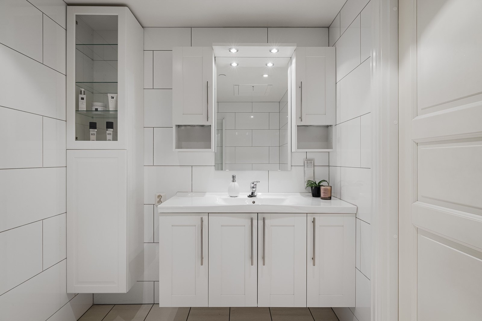 Lyst og pent flislagt bad med varmekabler i gulvet. Badet har en romslig innredning med underskap og heldekkende servant. Galleribilde