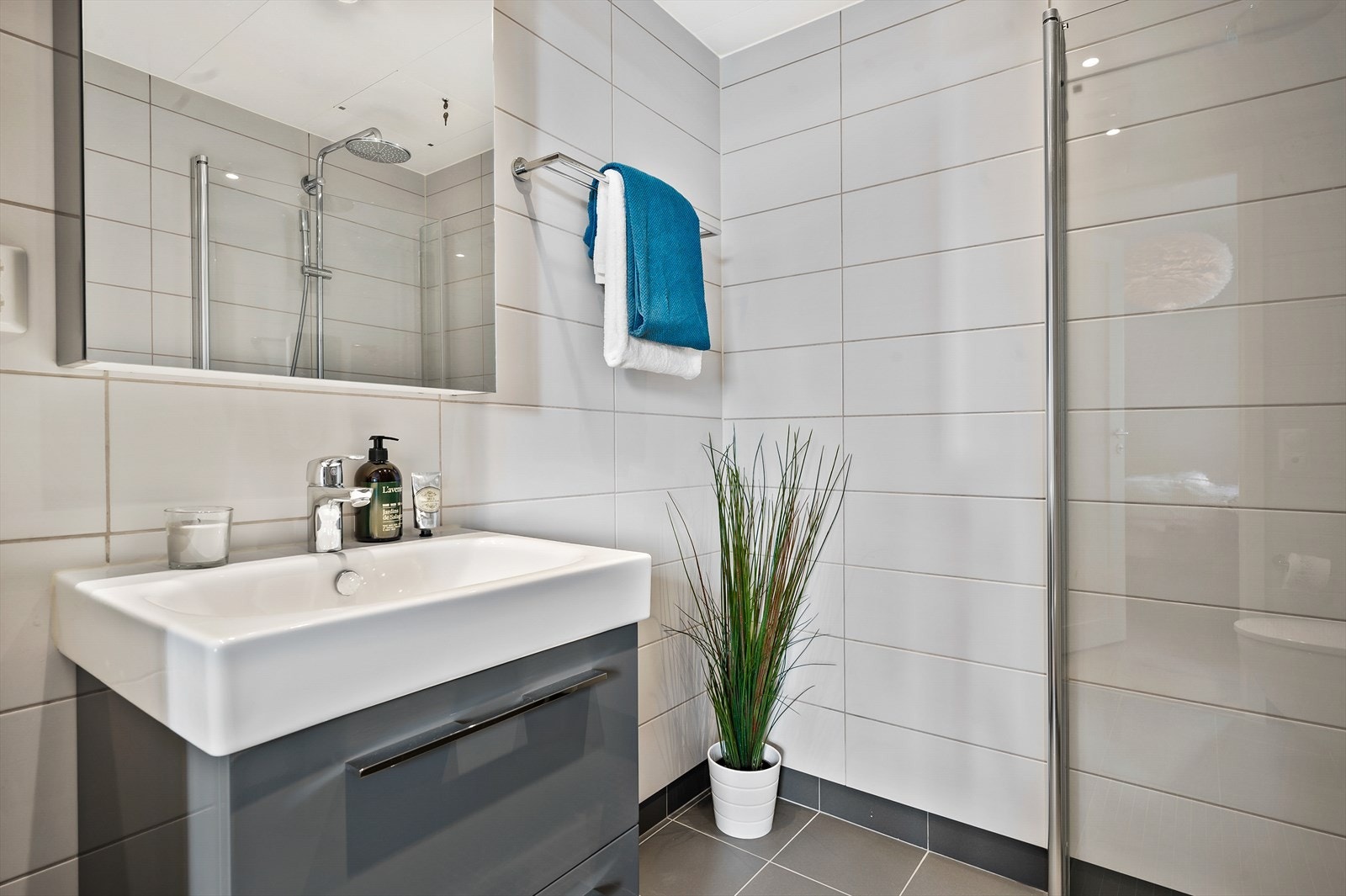 Baderomsinnredningen har skuffer og speilskap er vegghengt med integrert belysning. Galleribilde