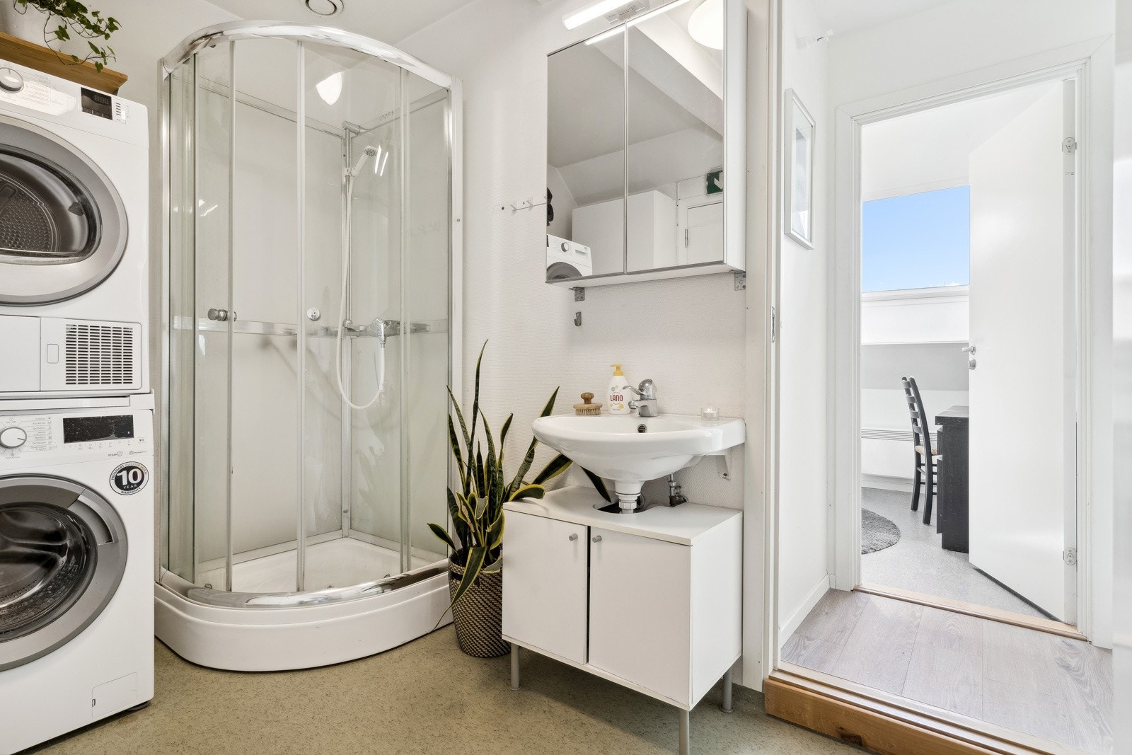 Bad utstyrt med blant annet vegghengt servant med armatur, dusjkabinett, speilskap med overlys og gulvstående toalett. Galleribilde