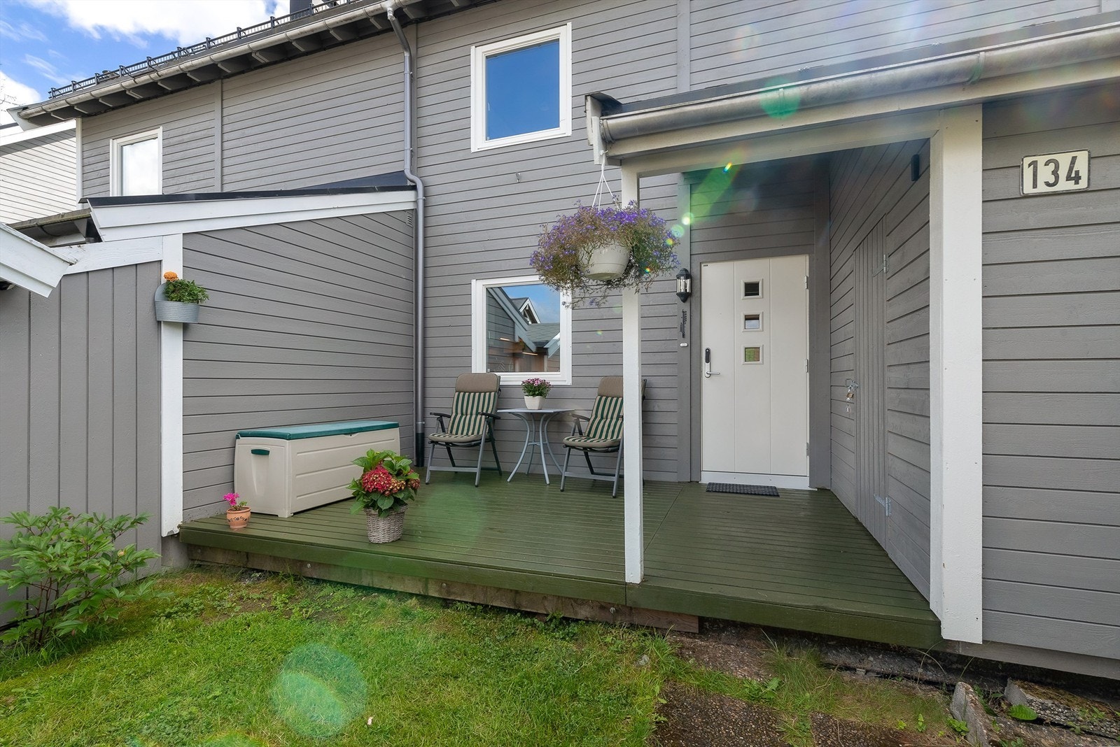 Ved boligens inngangsparti finner du også en ekstra terrasseplatting i tillegg til en romslig bod for oppbevaring. Galleribilde