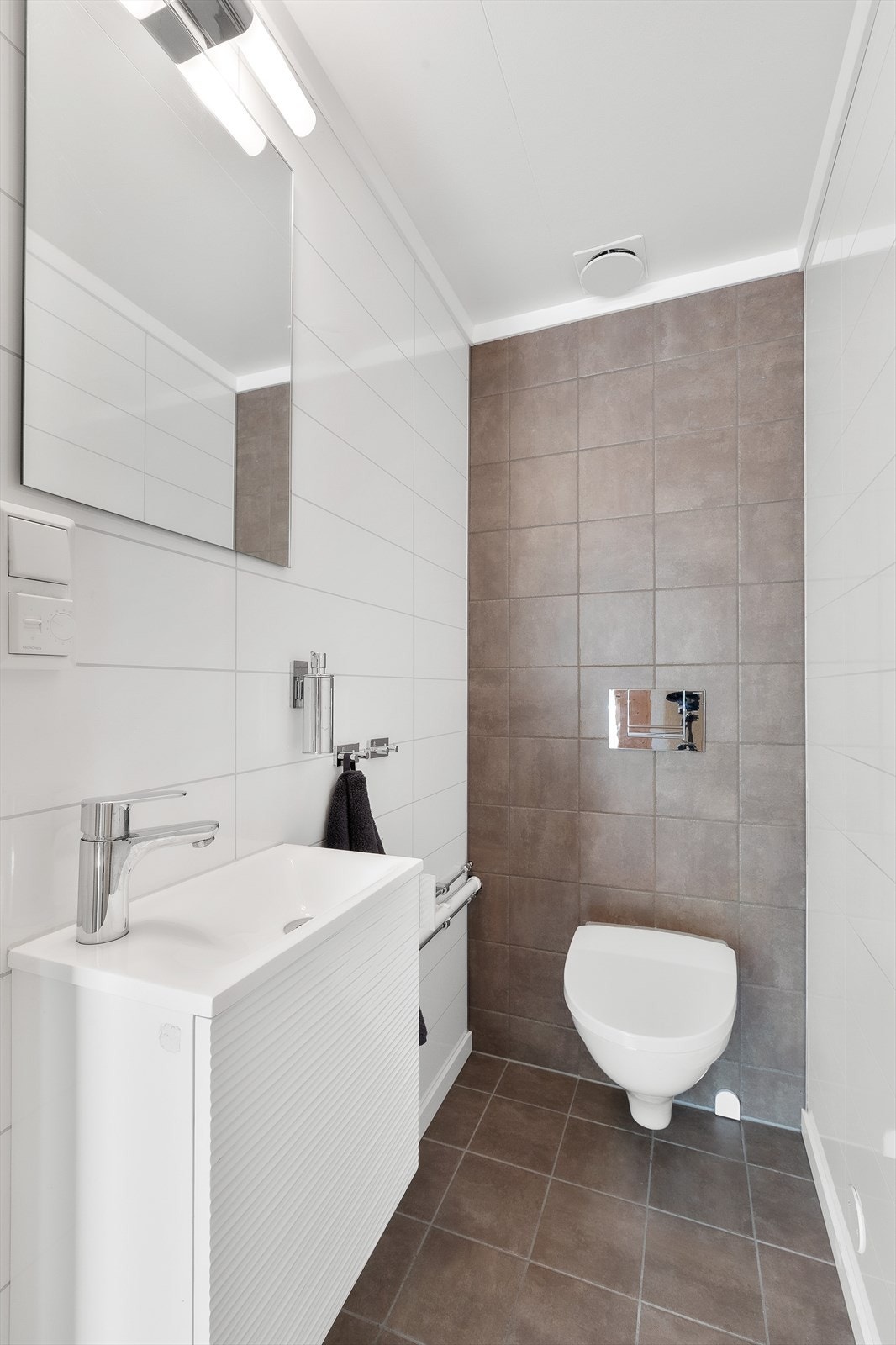 Også i 2. etasje finner du et eget toalettrom med flislagt gulv med varme og vegger med fliser og laminatplater. Toalettrommet har servant med underskap og vegghengt toalett. Galleribilde