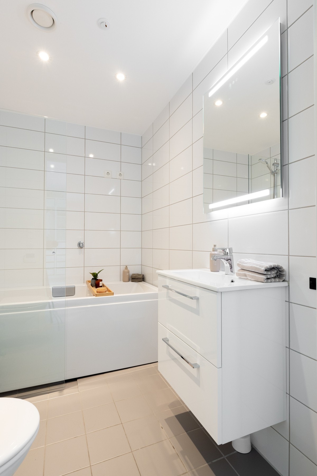 Badet er moderne innredet med speil med integrert belysning, spotter i taket og skuffeinnredning Galleribilde