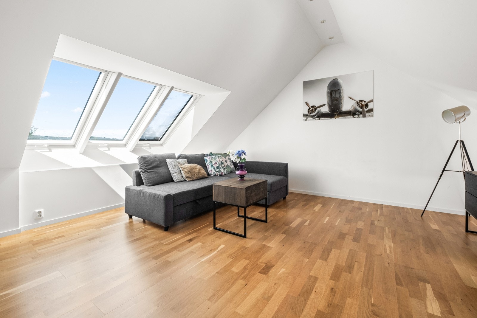 Romslig loftstue som fremstår som et moderne og stilrent rom - med herlig overlys fra takvinduer. Galleribilde