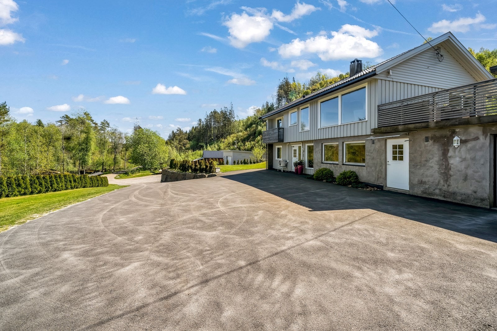 Asfaltert tun og parkeringsplass ved boligen + garasjer Galleribilde