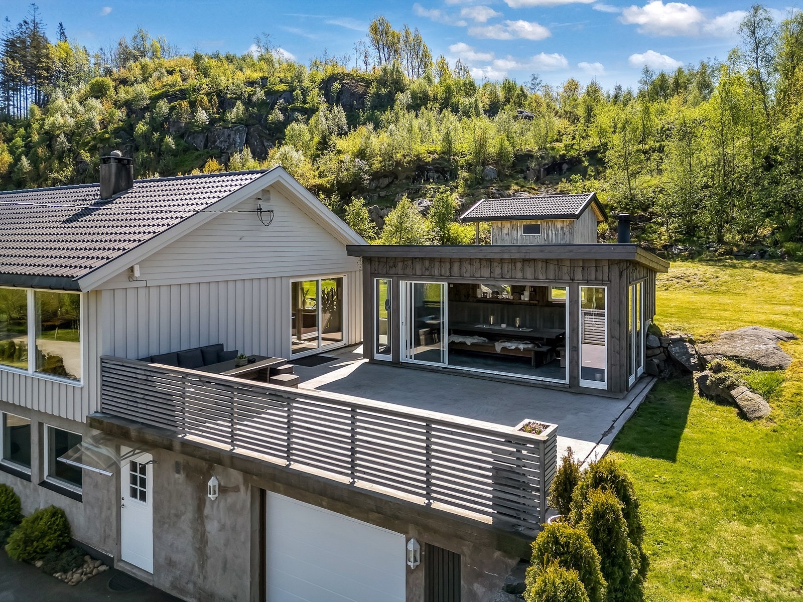 Stor terrasse i betong over garasjen, ved hagestuen. Galleribilde
