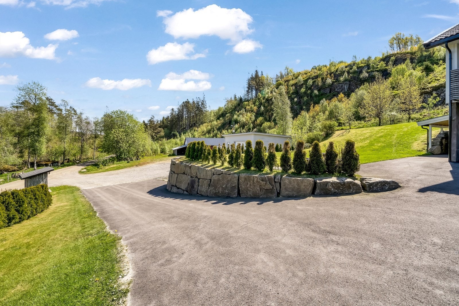 Del av tomten med adkomstvei - asfaltert siste stykket til huset Galleribilde