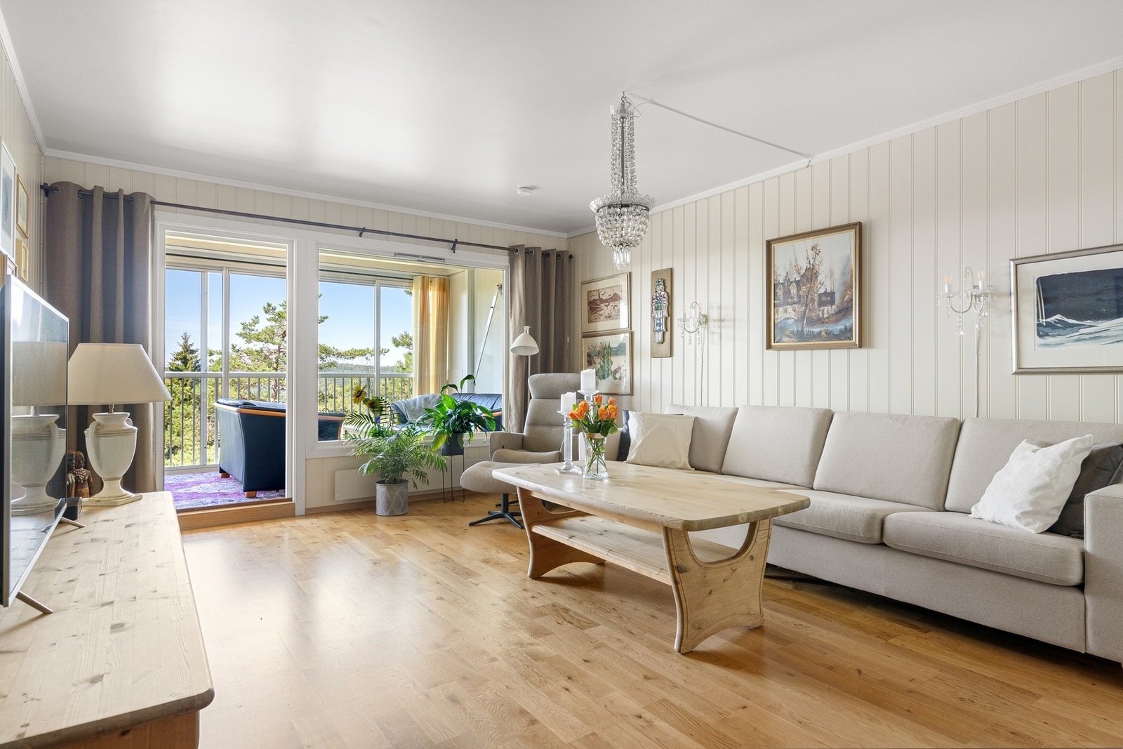 Stuen er romslig og de store vindusflatene slipper inn rikelig med naturlig lys Galleribilde