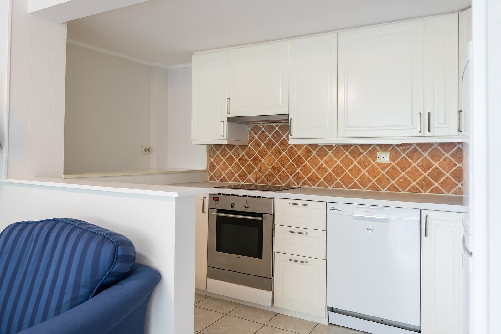 Lyst kjøkken med tilhørende hvitevarer. Galleribilde