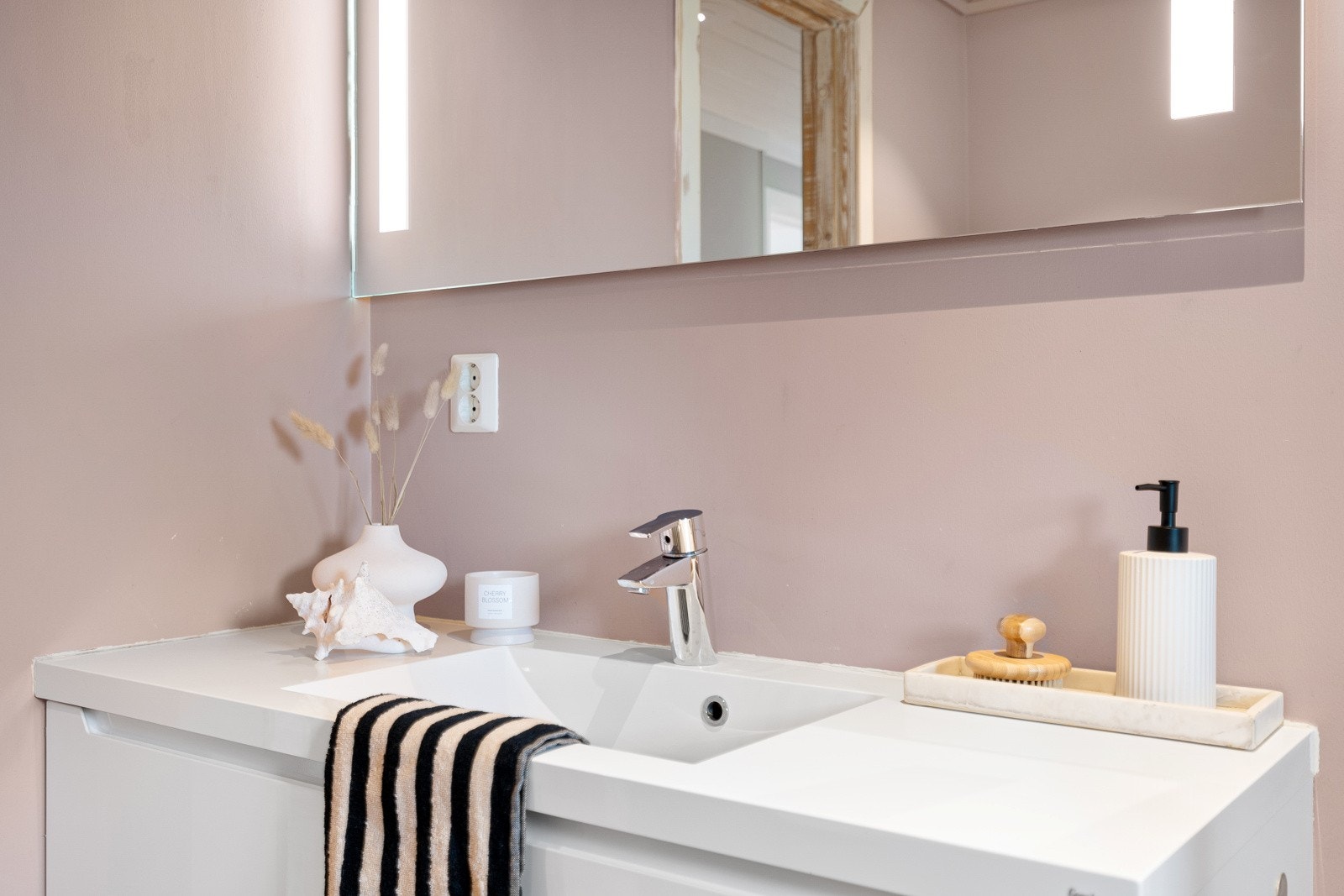 Badet er utstyrt med vegghengt servantinnredning, speil med sidelys, dusjhjørne og vegghengt toalett. Det er også downlights i himlingen og opplegg for vaskemaskin. Galleribilde