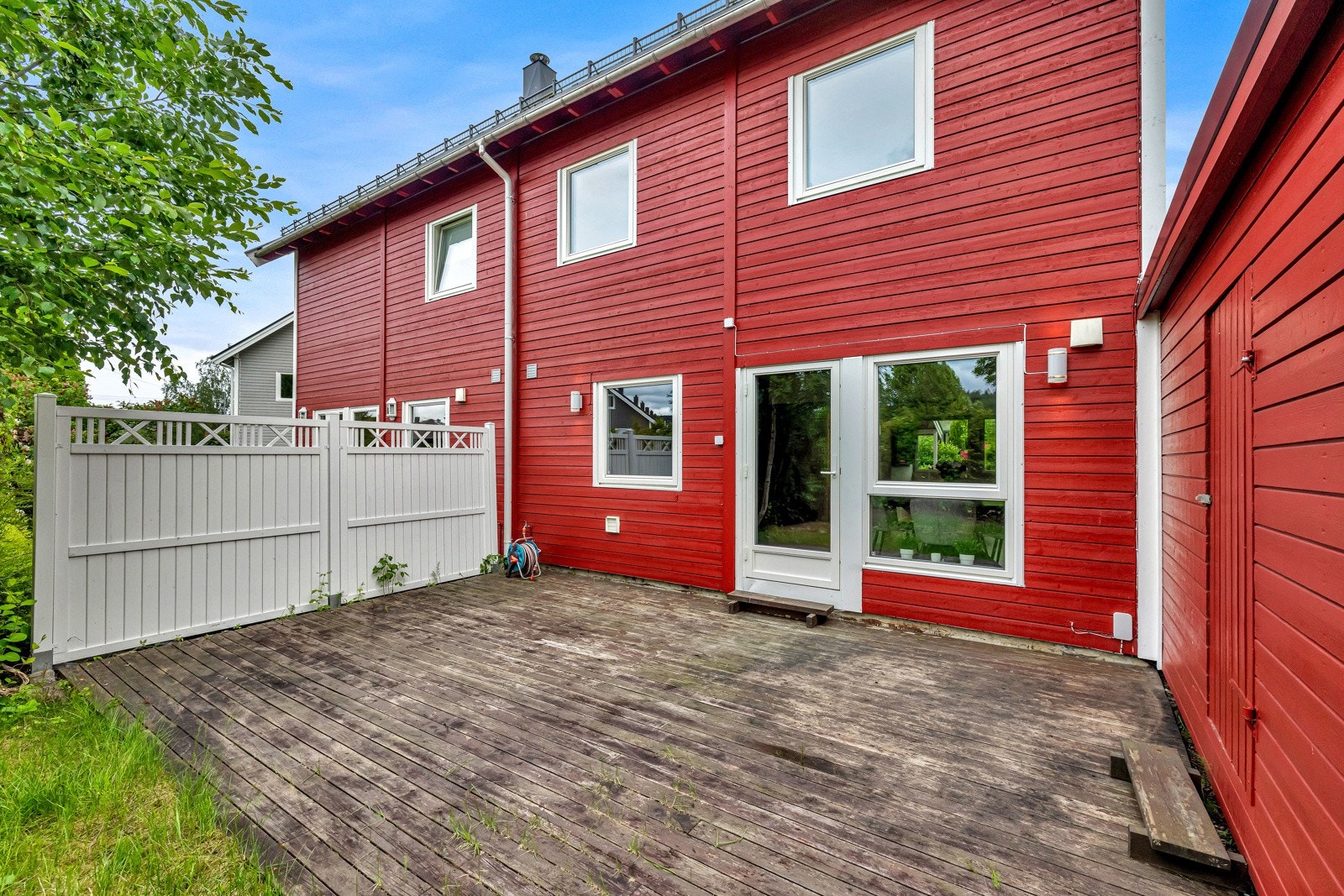 Terrassen skjermes av en utebod og en levegg mot naboen, og innbyr til både stille stunder og lange, sosiale kvelder Galleribilde