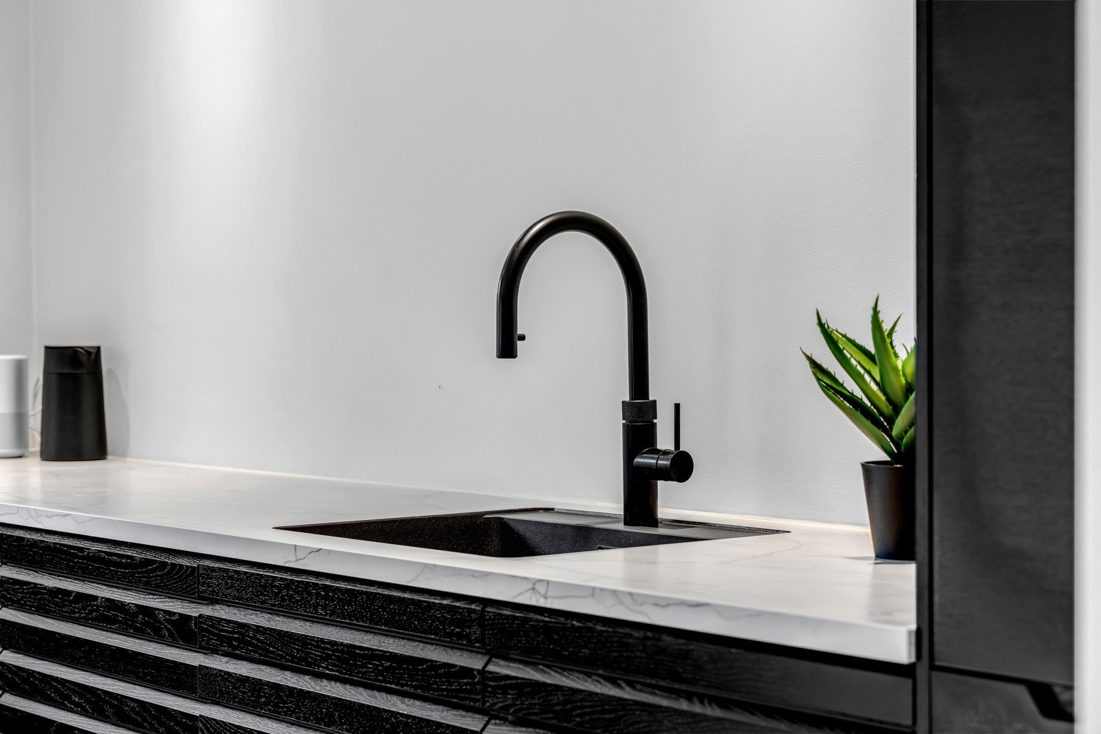 HTH-innredningen fra 2021 har sorte lamellfronter, benkeplate av laminat og oppvaskkum i kompositt med uttrekkbar Quooker-kran Galleribilde