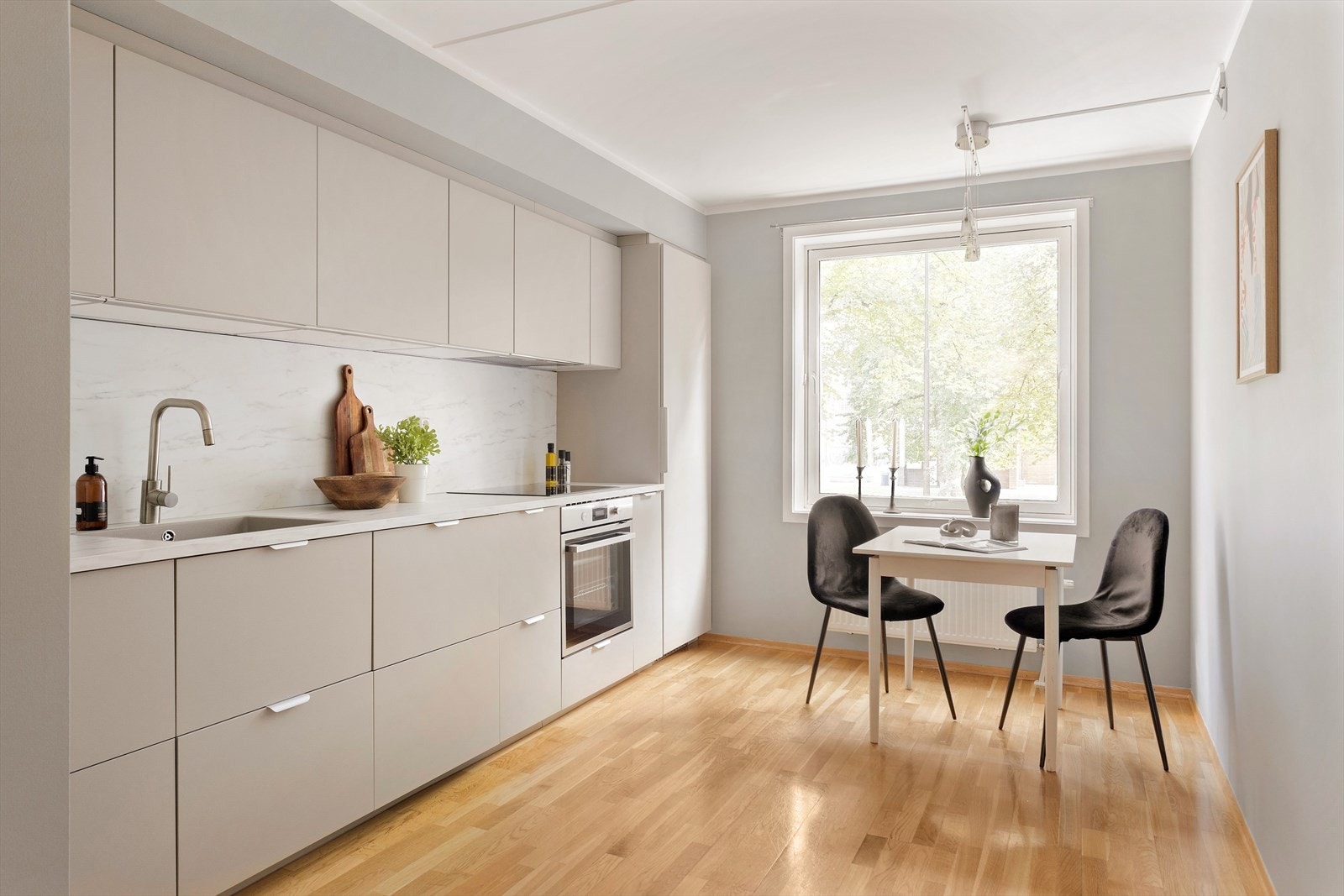 Moderne og stilren IKEA kjøkken fra 2024 med glatte fronter, integrerte hvitevarer og rikelig med skapplass Galleribilde