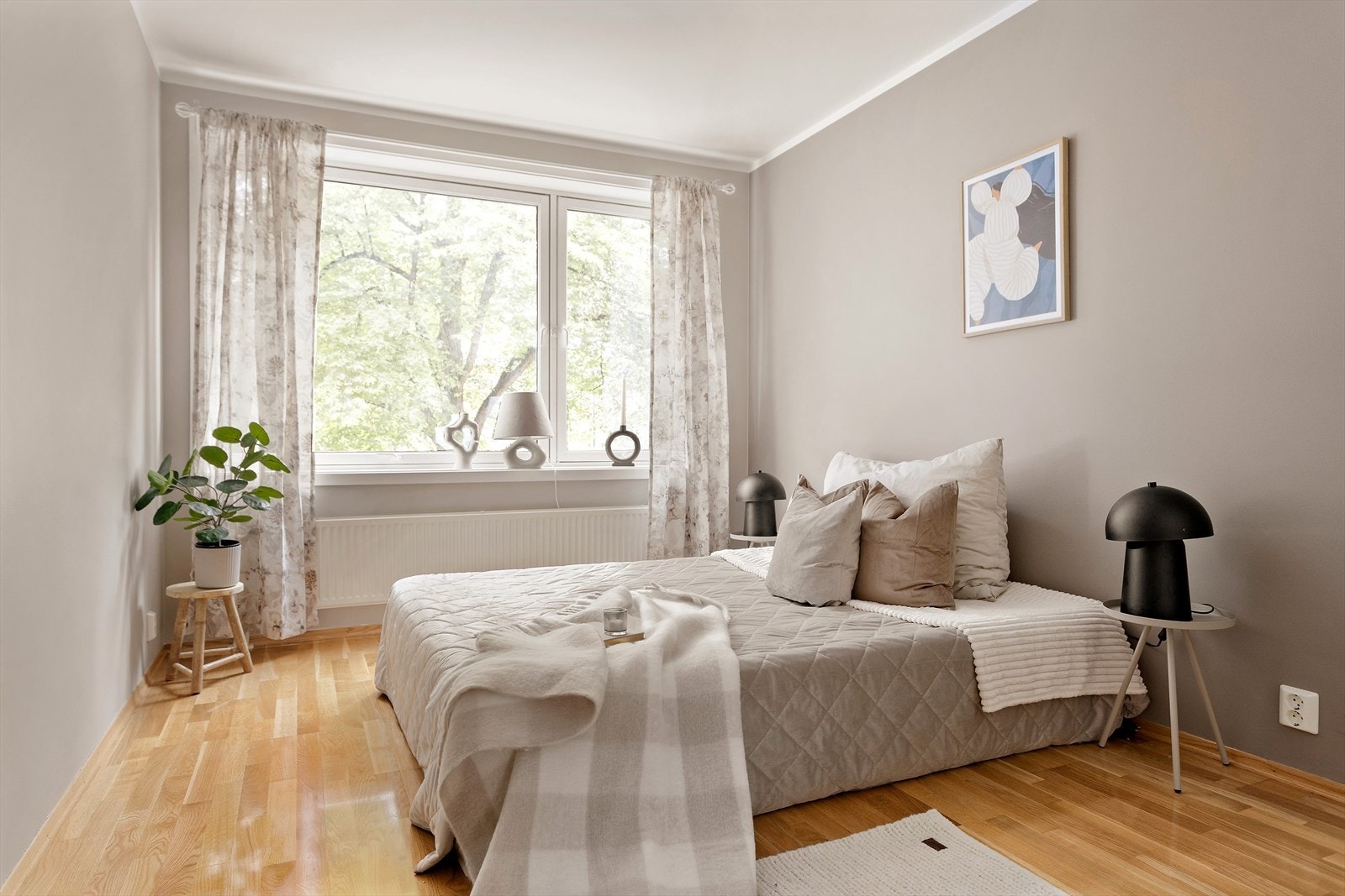 Innbydende soverom malt i en delikat farge med parkettgulv. Galleribilde