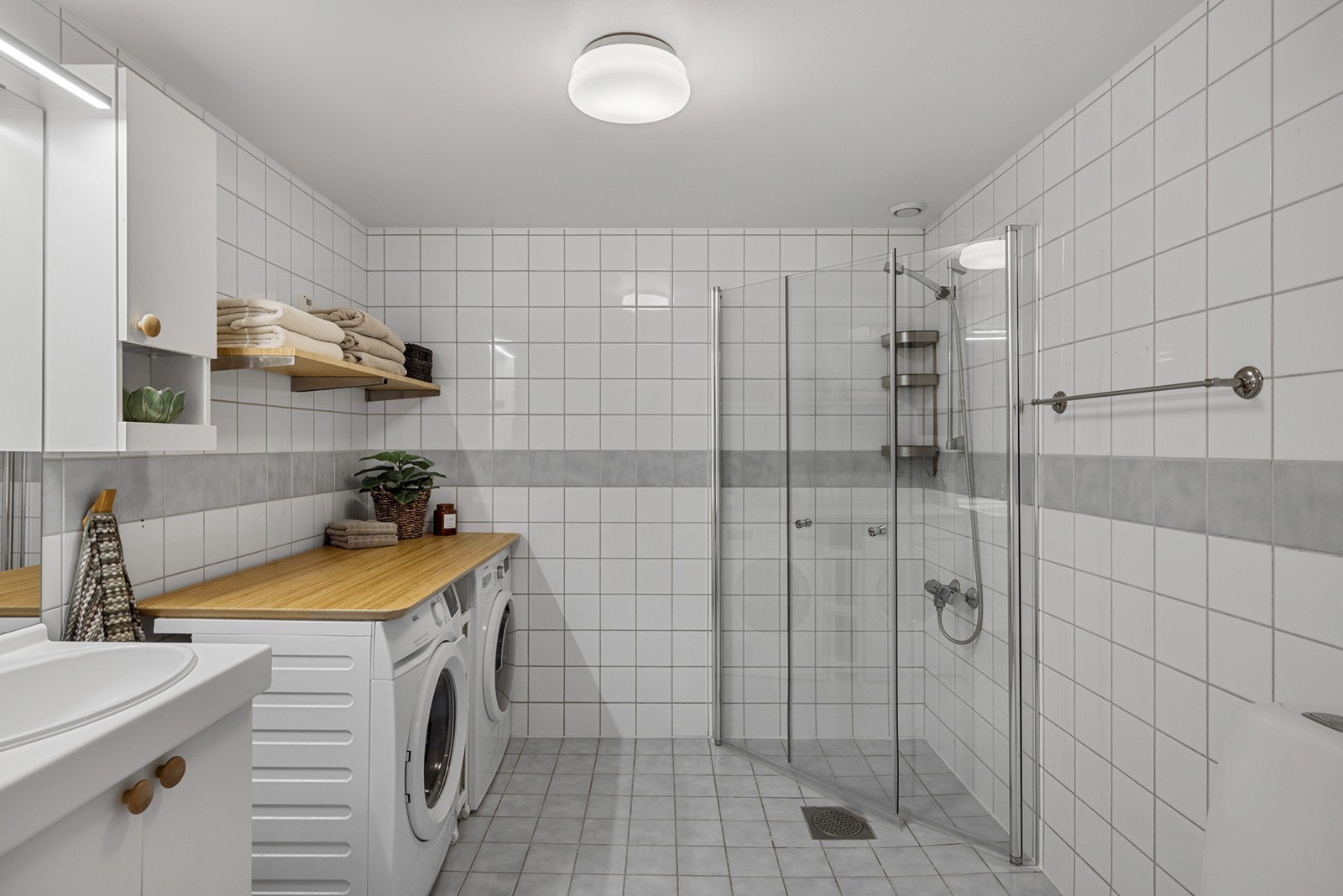 Innredningen består av et underskap/overskap, servant, speil, lys og stikk. En dusjsone med innfellbare dører. Galleribilde
