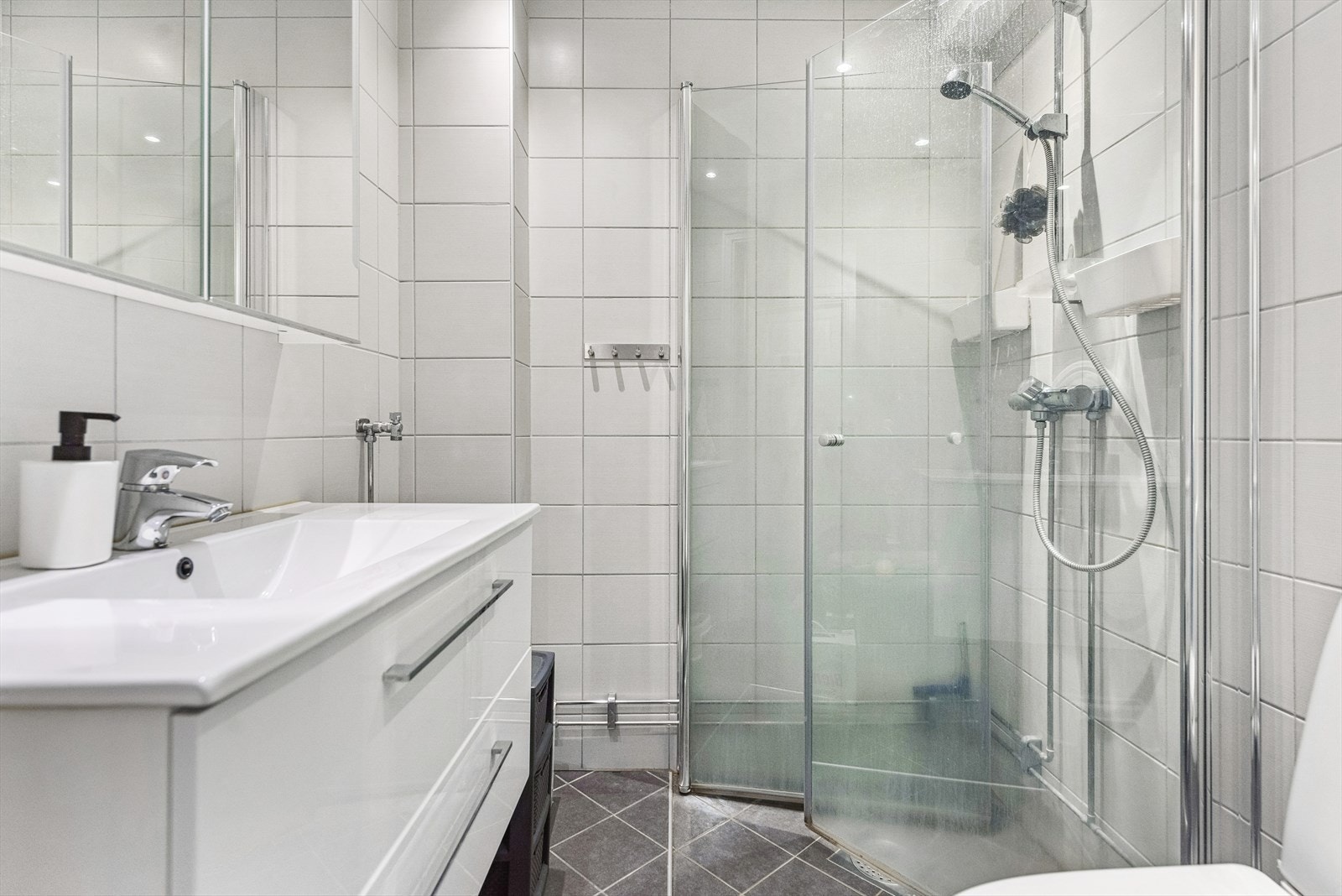 Pent flislagt bad/wc med varmekabler i gulv, servantskap og dusjnisje. Galleribilde