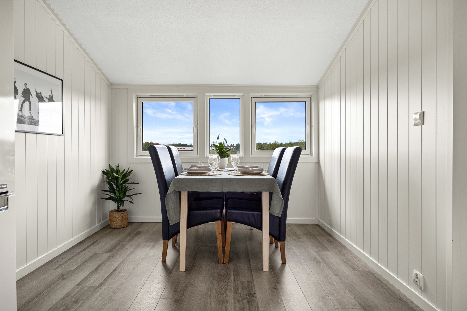 På kjøkkenet er det en hyggelig spiseplass under tre vinduer. Galleribilde