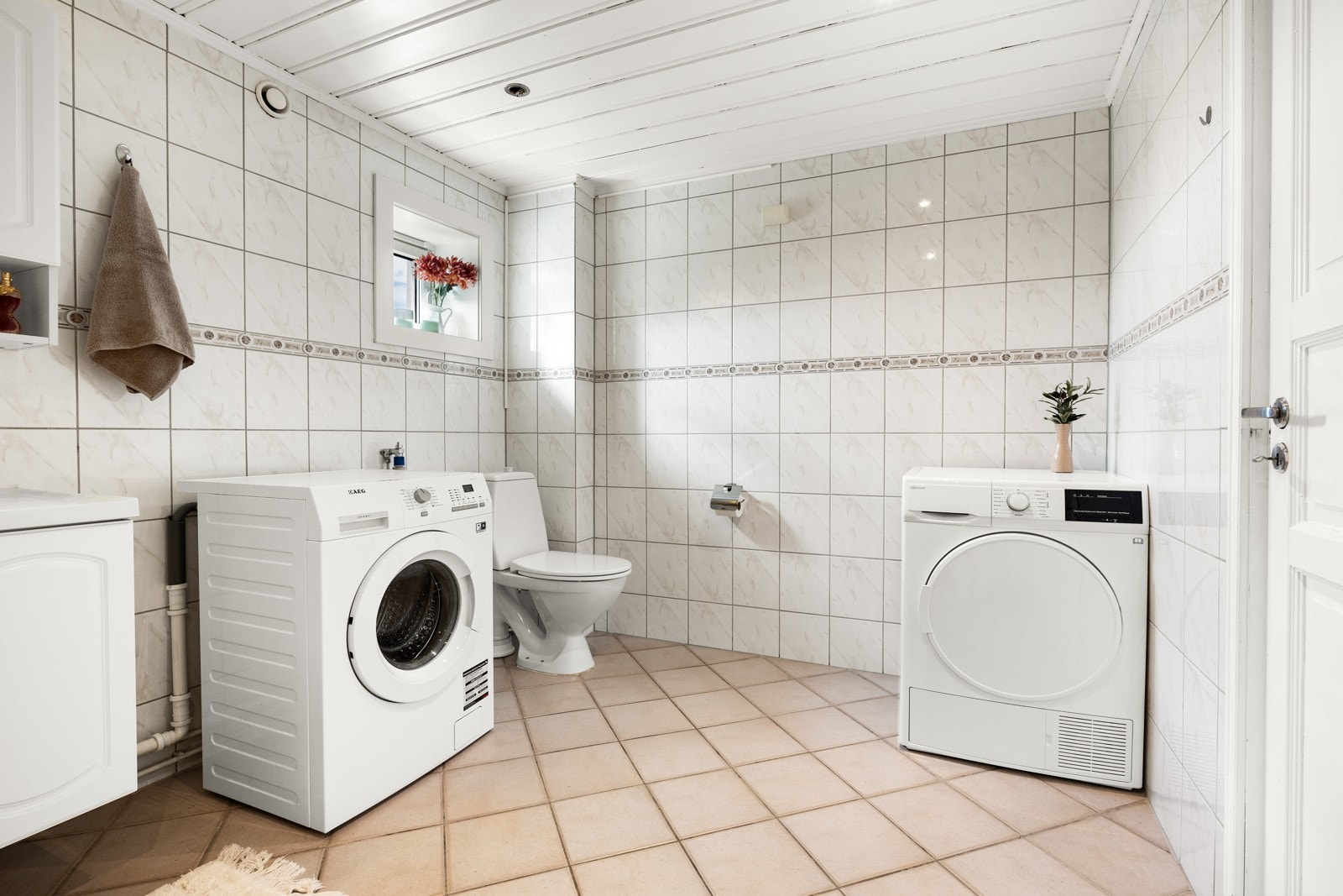 Baderommet er forholdsvis romslig og har pene overflater av sandfargede gulvfliser Galleribilde