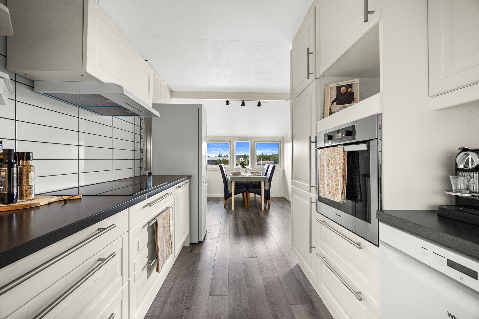 Benkeplaten er i sort laminat og har nedfelt, dobbel oppvaskkum med avrenningsfelt. Koketopp og stekeovn er integrert. Galleribilde