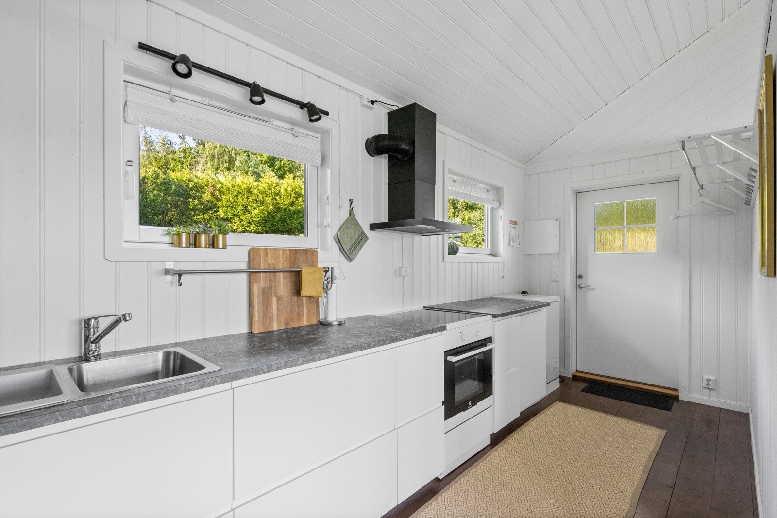Kjøkkeninnredningen har laminerte skrog og glatte fronter. Laminert benkeplate med kjøkkenkum. Plass til frittstående komfyr, kjøleskap og oppvaskmaskin. Kjøkkenventilator er montert over komfyr. Galleribilde
