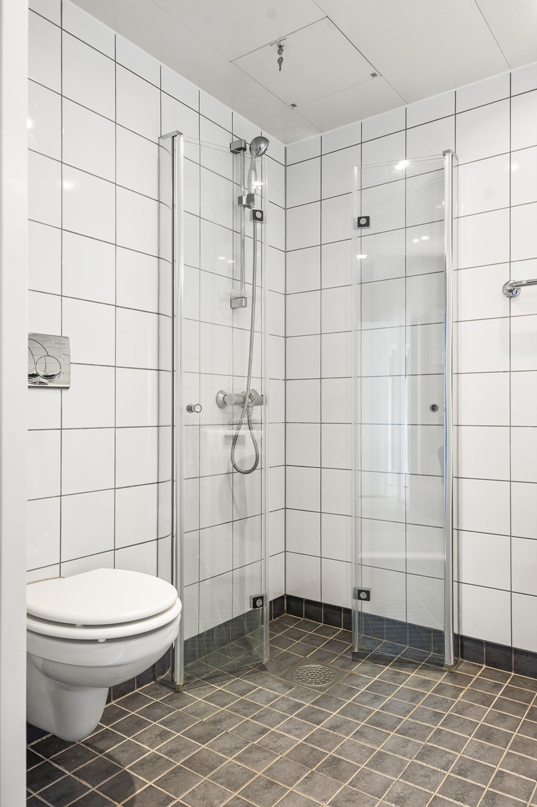 Innredningen består av servant med skapinnredning, speilskap med lys over servant, vegghengt toalett og dusjhjørne med innfellbare glassdører. Galleribilde