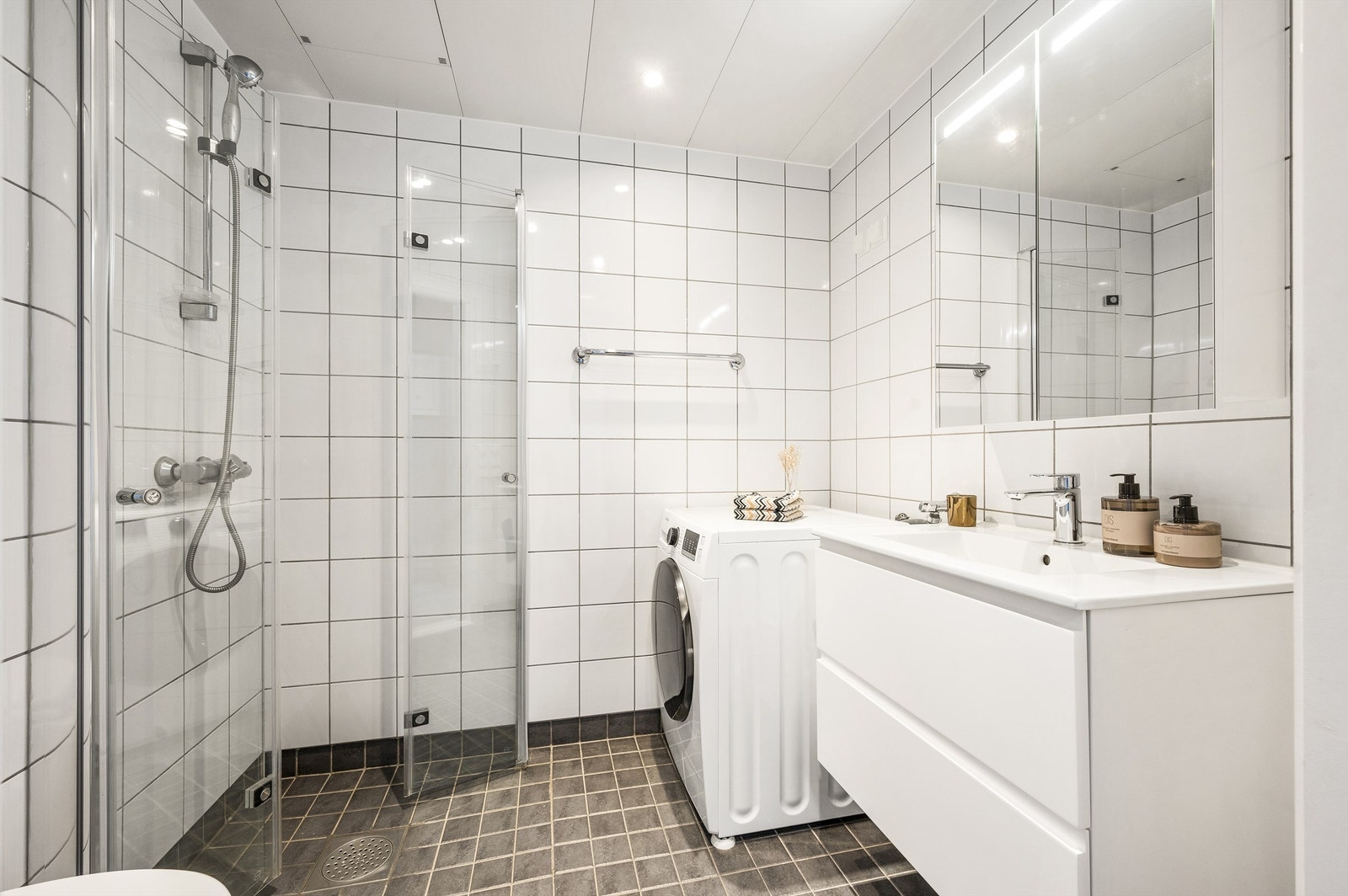 Delikat og pent flislagt bad med varme i gulv. Nedsenket himling med downlights. Galleribilde
