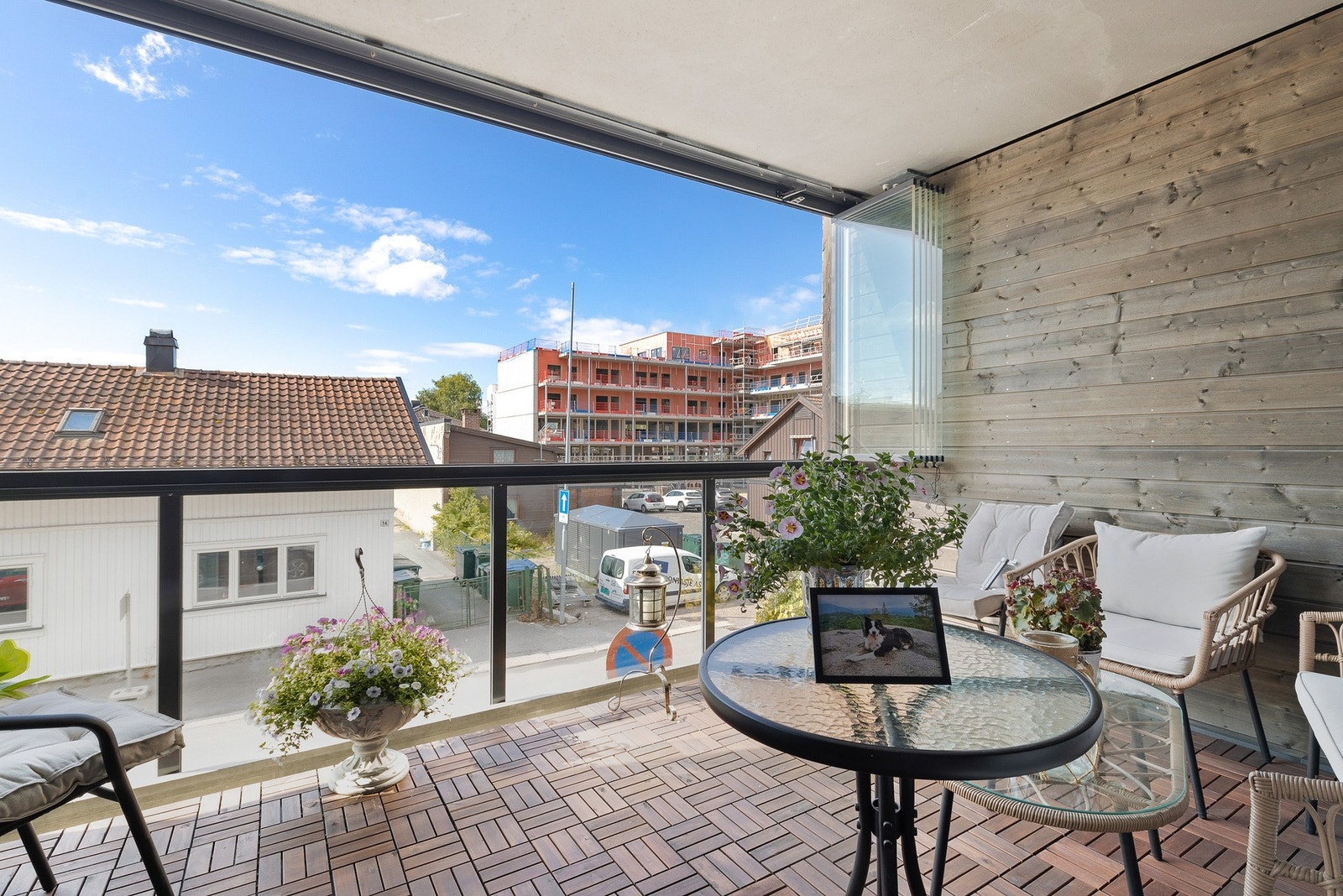 Boligen har en fin innglasset balkong på 10 kvm med trefliser på gulv og glassrekkverk Galleribilde