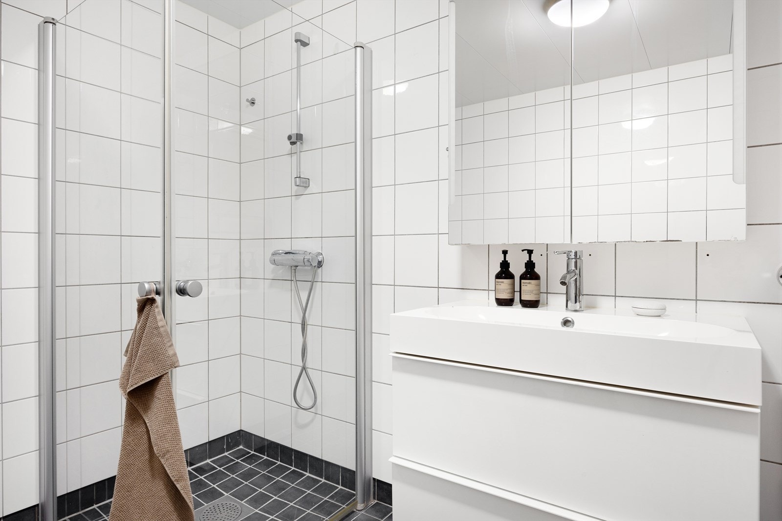 Det er varmekabler på gulvet, vask med under- og overskap, dusj, opplegg for vaskemaskin og plass til tørketrommel. Galleribilde