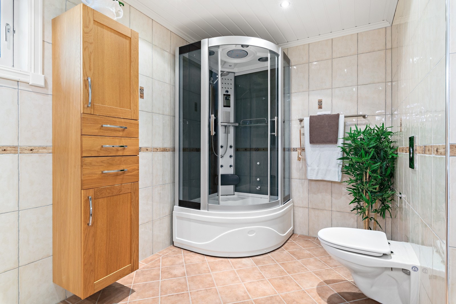 Badet er utstyrt med dusjkabinett og romslig baderomsinnredning. Galleribilde