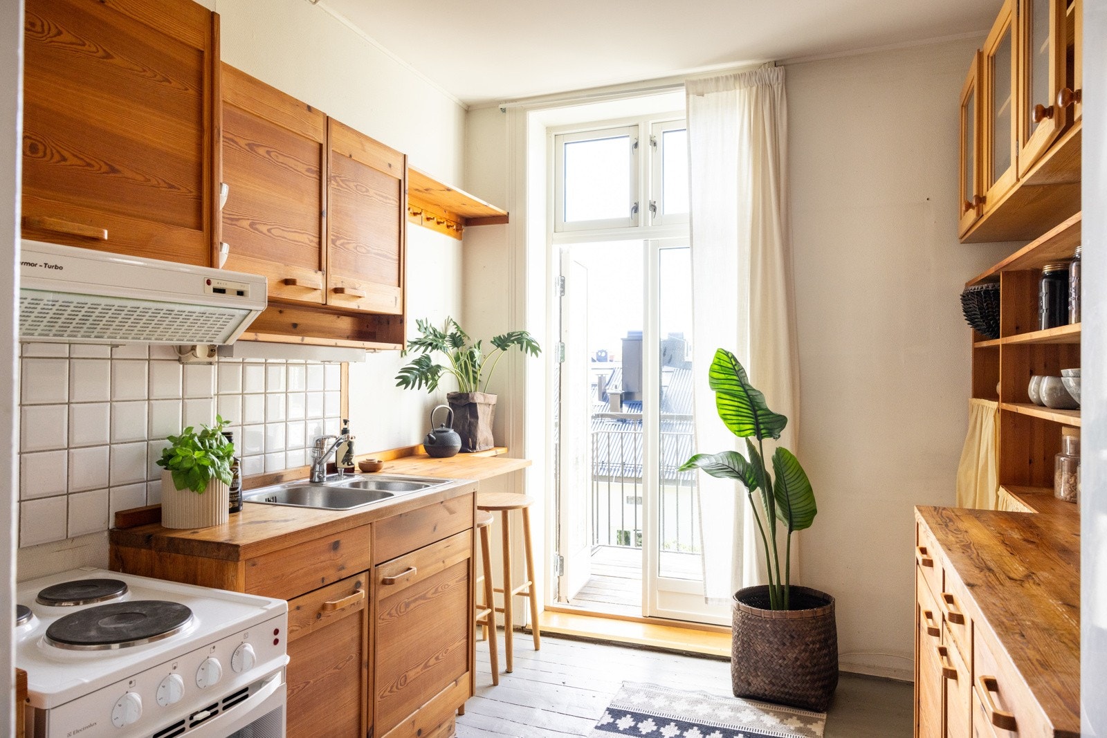 Eldre kjøkkeninnredning med profilerte furu fronter og furu benkeplate og en frittstående komfyr. Galleribilde