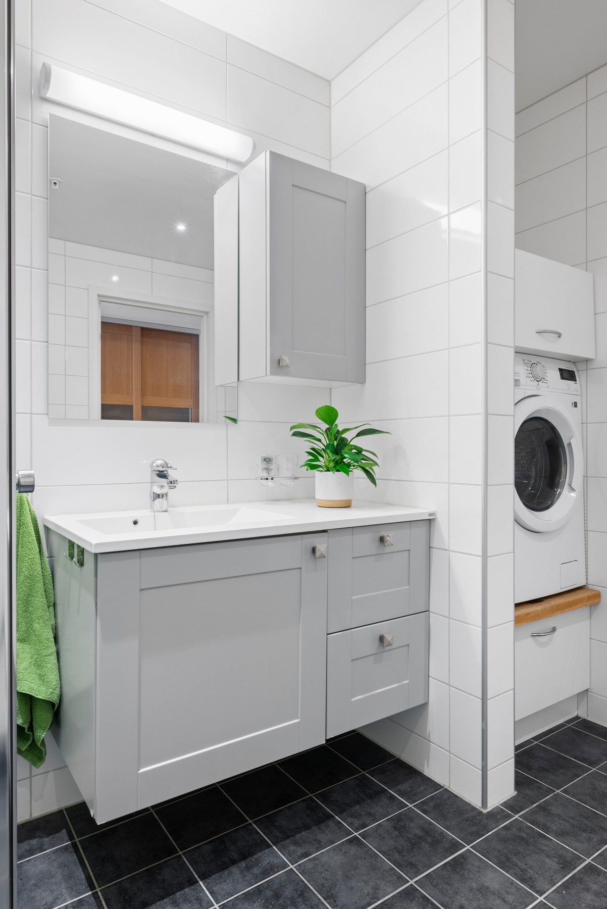 Her er det innredning med servant, servantskap, veggmontert wc, innfellbare dusjdører og opplegg for vaskemaskin. Galleribilde