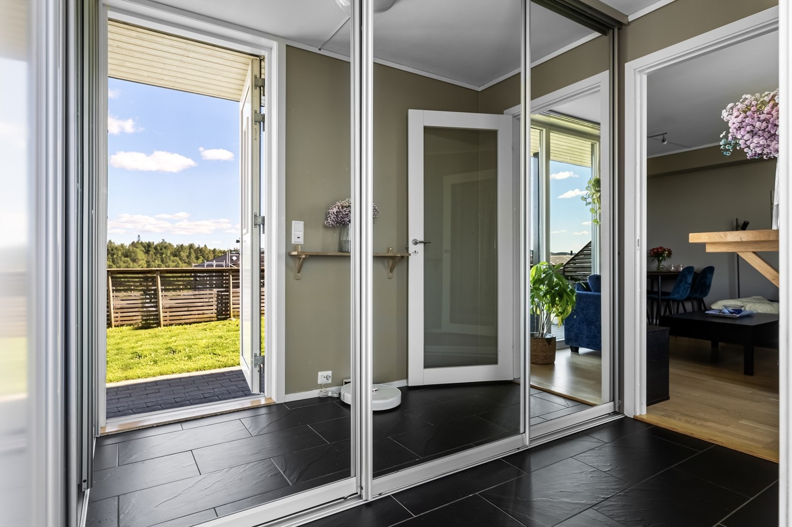 Egen inngang med flislagt entre og stor og praktisk skyvedørsgarderobe med speilfronter. Galleribilde