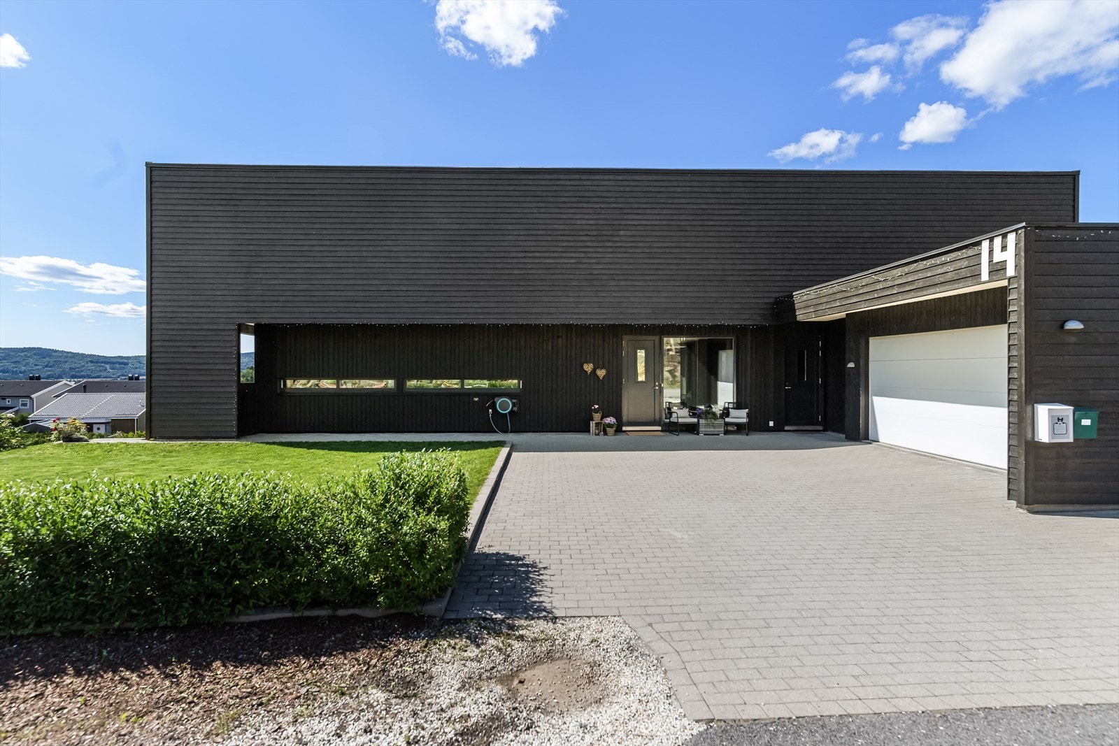 Et velstelt gårdsrom med belegningsstein og takoverbygget inngangsparti ønsker velkommen. Galleribilde