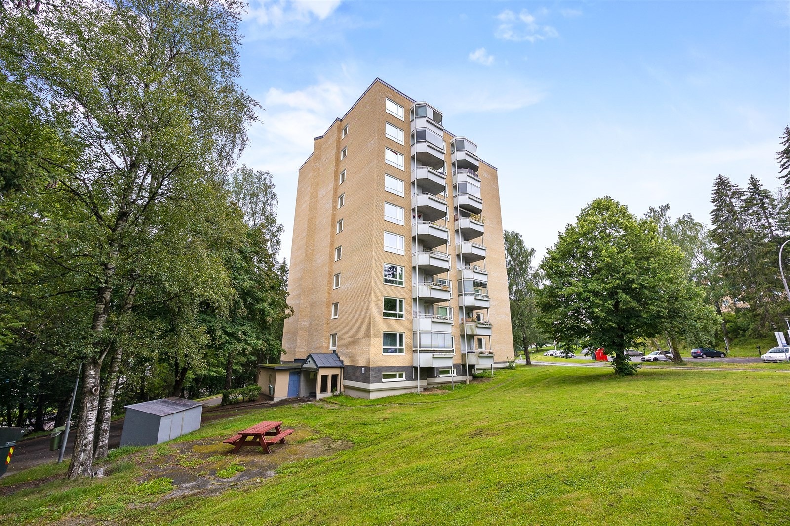 Velholdt bygning omgitt av grøntområder. Galleribilde