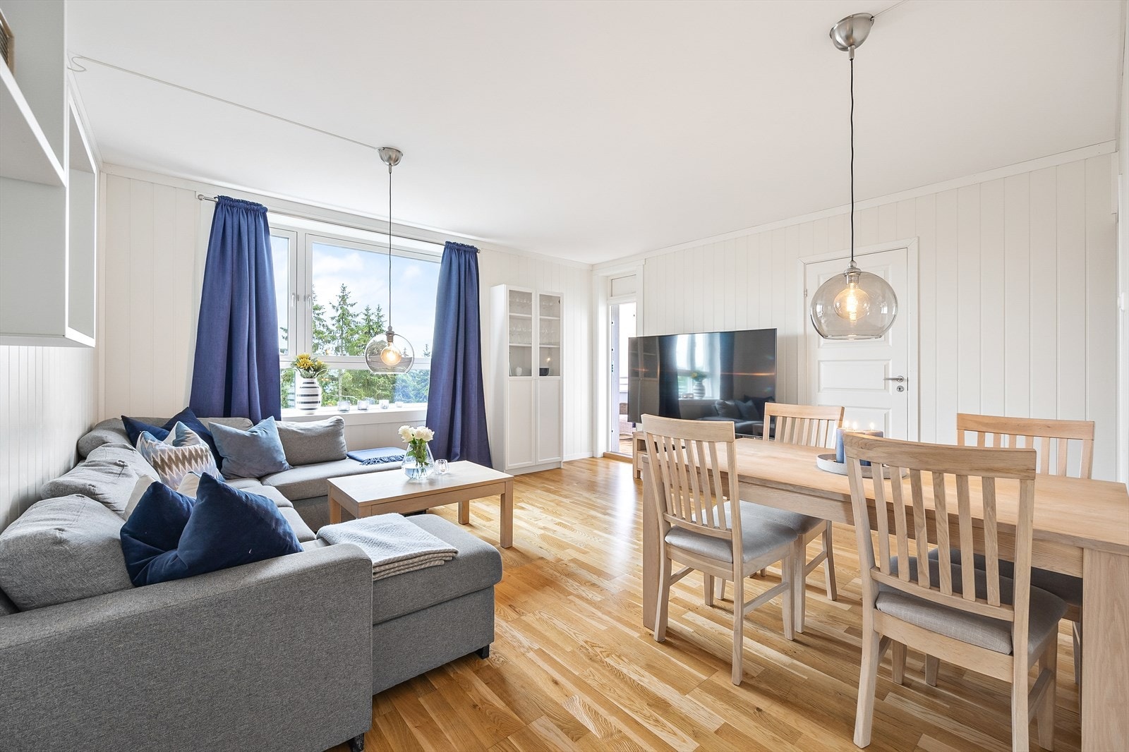 Store vinduer og hjørneløsning gir stuen en lys og luftig atmosfære. Galleribilde